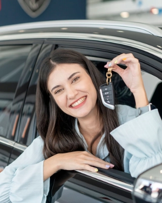 Auto-Leasing fuer junge Erwachsene - junge Frau mit ihrem geleasten Wagen.